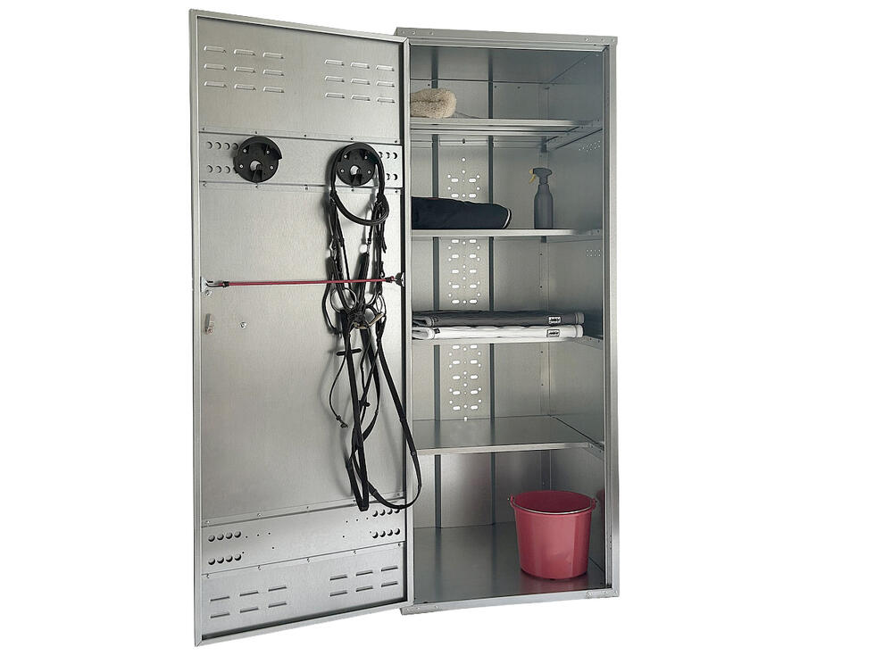 Ein Deckenschrank verzinkt geöffnet mit zwei Trensenhalter auf der Innenseite der Türe und vier Tablaren im Hauptteil, resultierend in fünf Fächern, Frontalansicht