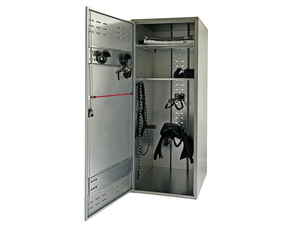 Ein Sattelschrank verzinkt geöffnet mit zwei Trensenhalter auf der Innenseite der Türe und zwei Tablaren im Hauptteil, resultierend in drei Fächern, von welchen im grössten und untersten zwei übereina