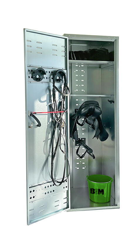 Ein Sattelschrank verzinkt geöffnet mit zwei Trensenhalter auf der Innenseite der Türe und zwei Tablaren im Hauptteil, resultierend in drei Fächern, von welchen im grössten und untersten zwei übereina