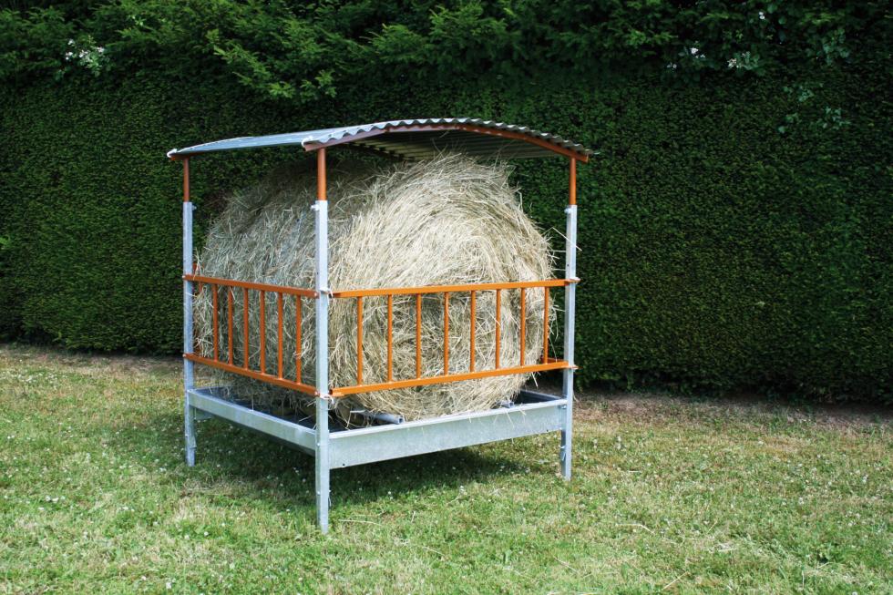 Ein Behandlungs- und Einfangstandstand mit Liegegitter und Schwenkachse, vorne zwei feste schwarze Räder, auf der Hinterseite ein schwarzes Brett, Schaf eingespannt umgedreht, wessen Klauen von einer Person geschnitten werden