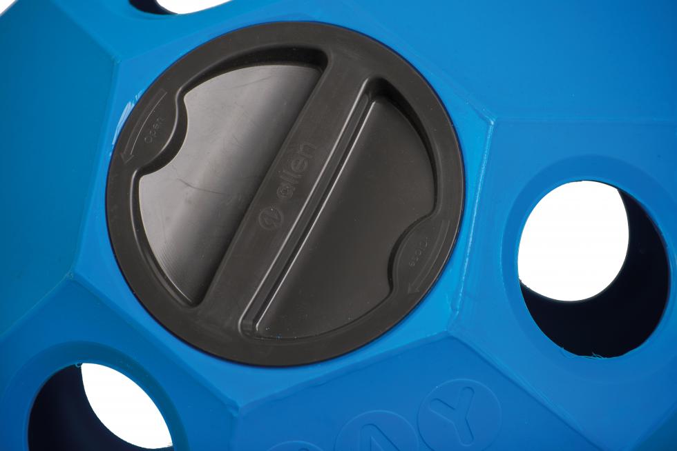 Der Teil eines blauen vieleckigen Heuspielballes in Grossaufnahme des schwarzen Schraubverschlussdeckels, Kunststoff