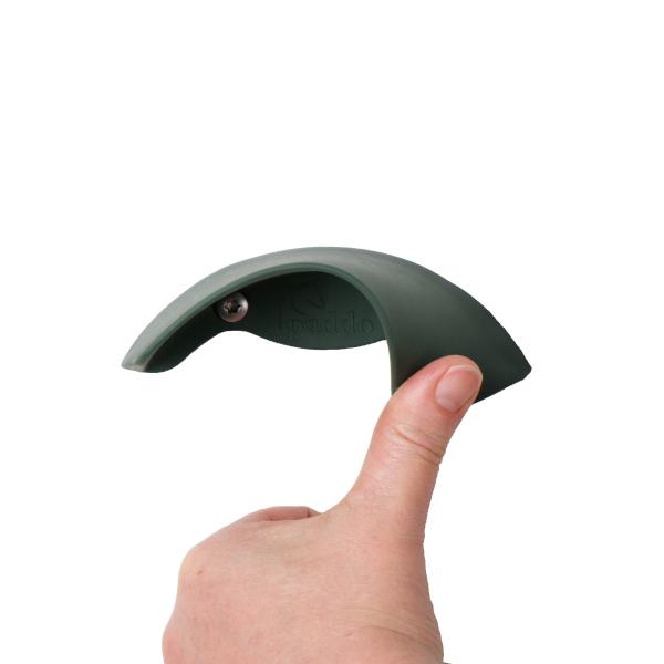 Ein Flacheisen, fixiert mit zwei Schrauben, daran befestigt ist ein halbrunder Gummivorsatz in schwarz, montiert an einer Holzwand, darauf aufgelegt eine grüne Trense