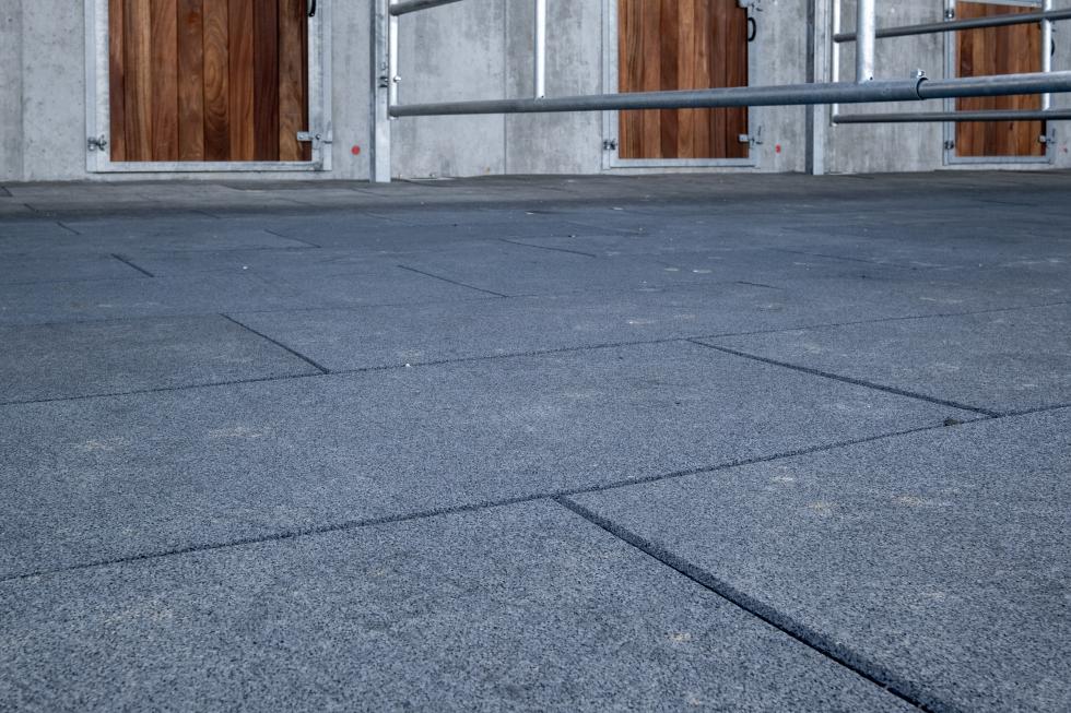 Ein weisser Raum mit schräg versetzt verlegten, roten Komfortexplatten, Ansicht von aussen in den Raum hinein