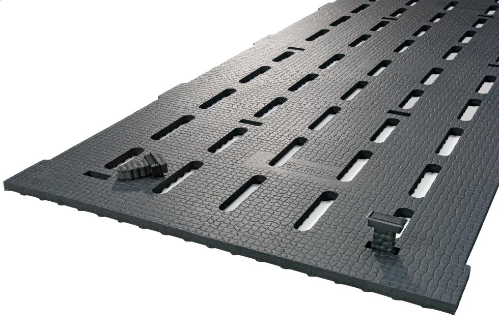 Gummimatte mit Noppen auf der Unterseite, dem Lauf folgende, regelmässig angeordnete Spalten, am vorderen Ende zwei Zapfen zur Fixation