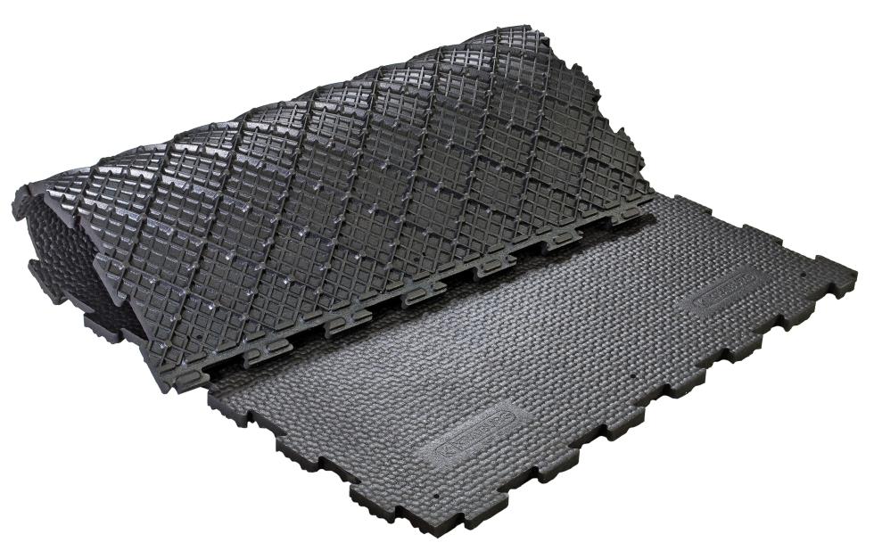 Eine schwarze Puzzlegummimatte, in der Hälfte umgeschlagen, oben Hammerschlagprofil, Rautenmuster auf der Unterseite genoppt