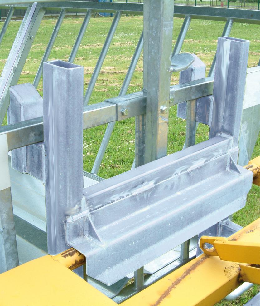 Ein Behandlungs- und Einfangstandstand mit Liegegitter und Schwenkachse, vorne zwei feste schwarze Räder, auf der Hinterseite ein schwarzes Brett, Schaf eingespannt umgedreht, wessen Klauen von einer Person geschnitten werden